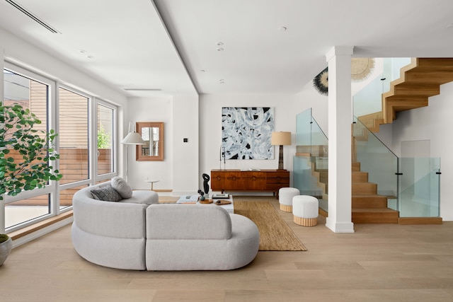 living area featuring stairs, wood finished floors, and baseboards
