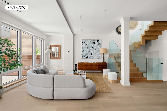 living room with stairway, wood finished floors, and baseboards