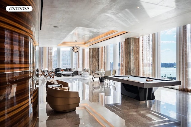 35 Hudson Yards Unit 5302, New York City, NY 10001 - recreation room featuring healthy amount of natural light, a tray ceiling, and a chandelier