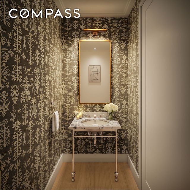 bathroom featuring wallpapered walls, baseboards, vanity, and crown molding