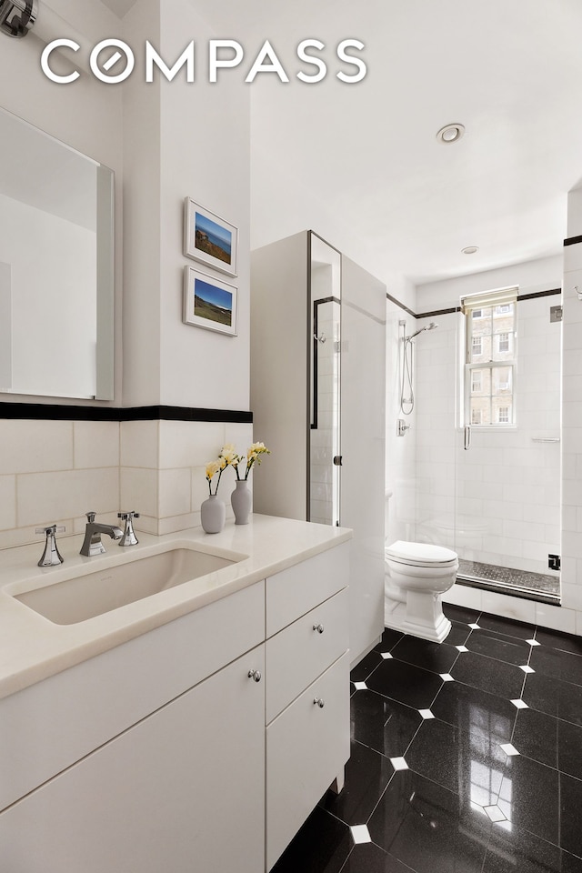 bathroom with a shower stall, toilet, vanity, and recessed lighting