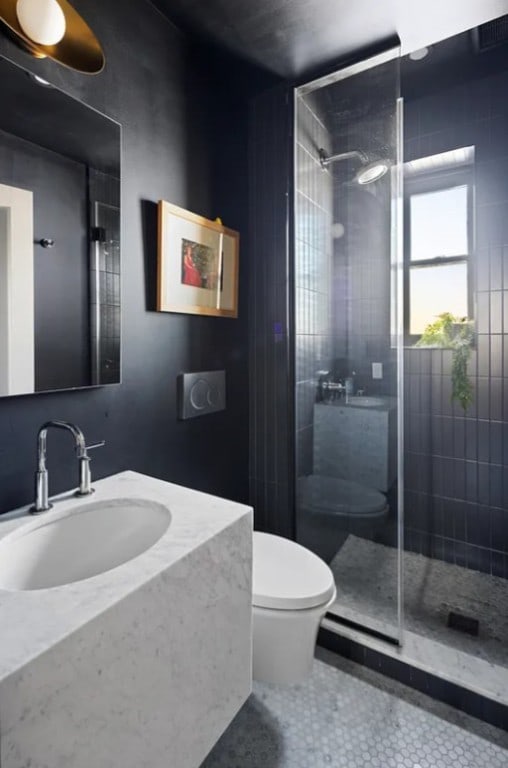 full bath with tile patterned floors, toilet, tiled shower, and vanity