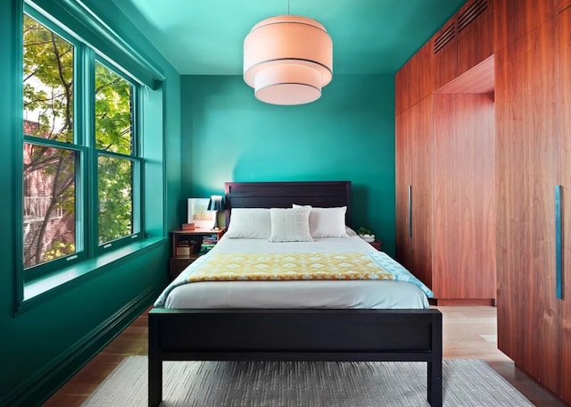 bedroom featuring multiple windows and wood finished floors