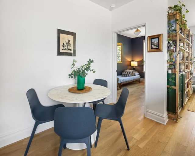 dining area featuring light wood-style floors and baseboards