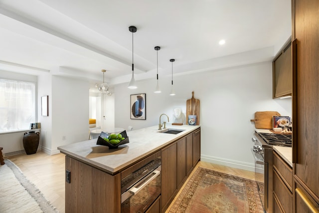 kitchen with high end stainless steel range oven, a sink, a peninsula, baseboards, and recessed lighting