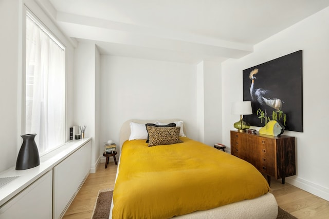 bedroom featuring light wood finished floors and baseboards