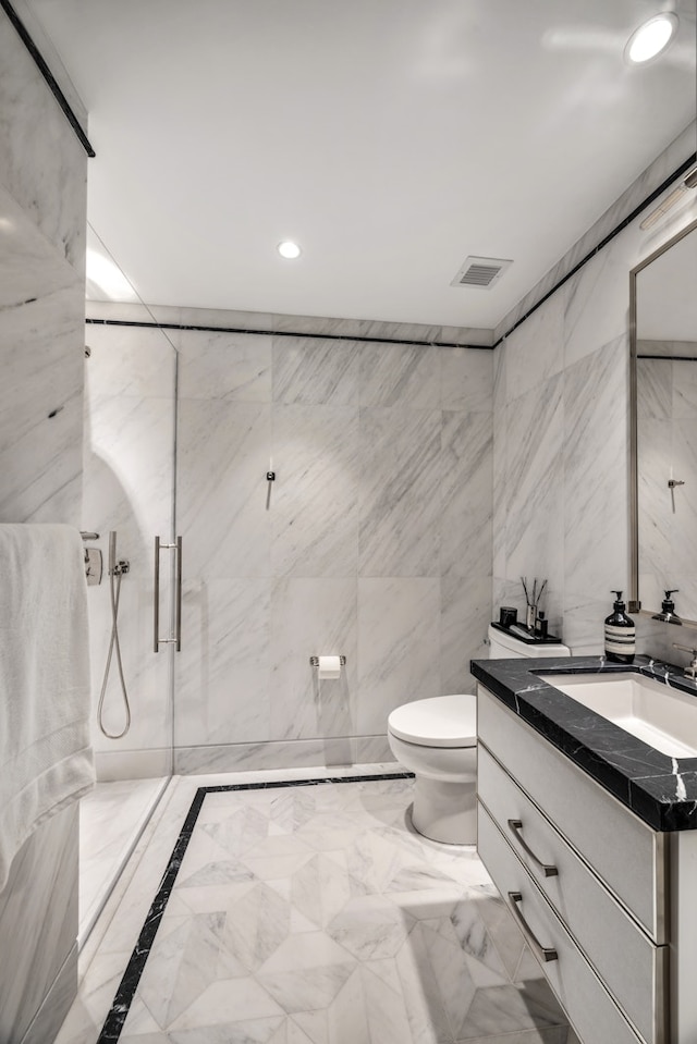 full bathroom featuring toilet, a marble finish shower, vanity, recessed lighting, and marble tiled floors