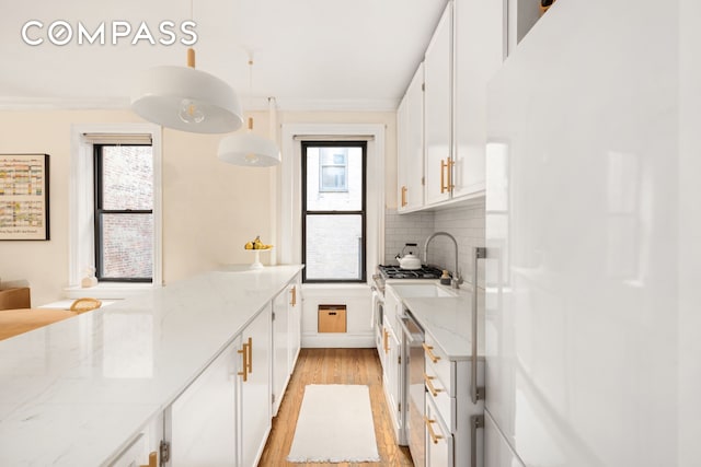 205 E 10th St Unit 3A, New York City, NY 10003 - kitchen with freestanding refrigerator, dishwasher, white cabinets, light wood-type flooring, and a peninsula