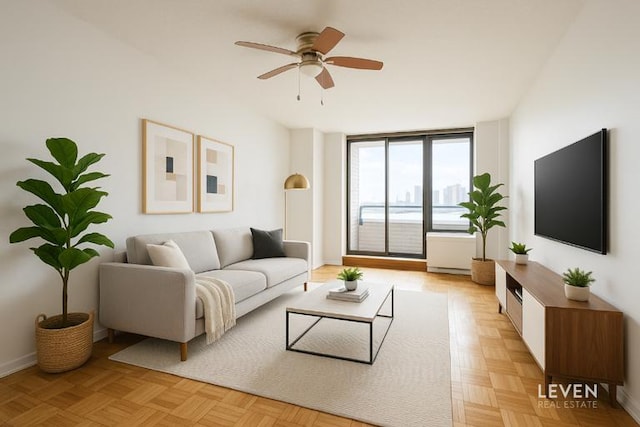 living area featuring ceiling fan and baseboards