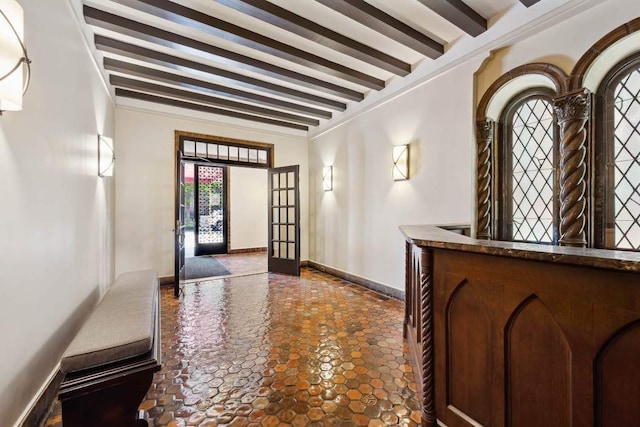 entrance foyer featuring beam ceiling, baseboards, stone finish flooring, and french doors