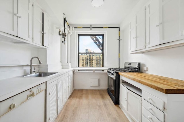 kitchen featuring gas range, dishwasher, wood counters, a sink, and light wood-style floors