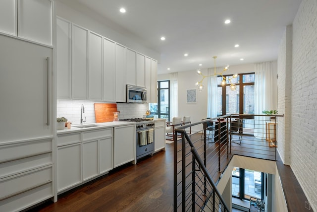 558 W 150th St Unit 101, New York City, NY 10031 - kitchen with appliances with stainless steel finishes, a sink, tasteful backsplash, dark wood-type flooring, and recessed lighting