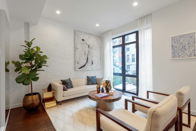 558 W 150th St Unit 101, New York City, NY 10031 - living area with light wood-style flooring, recessed lighting, brick wall, and baseboards