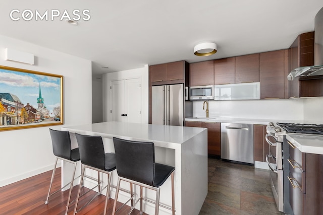 301 W 118th St Unit Ph1C, New York City, NY 10026 - kitchen featuring stainless steel appliances, wall chimney range hood, light countertops, a center island, and a kitchen breakfast bar