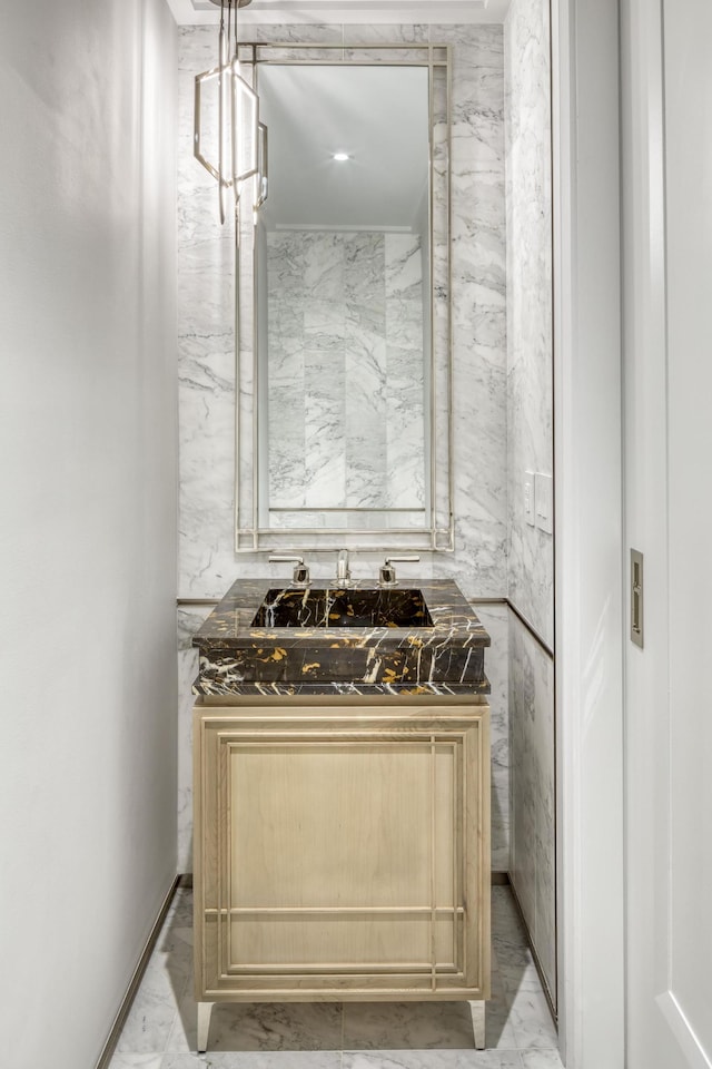 kitchen with light marble finish floors, dark countertops, and a sink