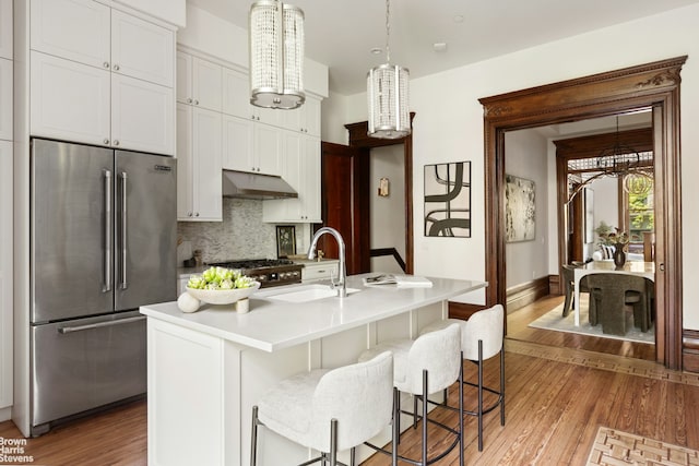 221 W 113th St, New York City, NY 10026 - kitchen with high end fridge, a sink, light wood-style floors, and backsplash