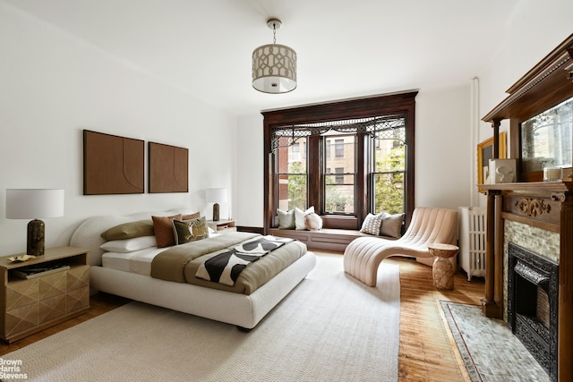 221 W 113th St, New York City, NY 10026 - bedroom featuring wood finished floors, multiple windows, a fireplace, and radiator
