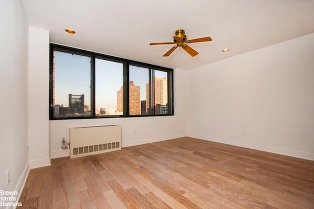 300 E 90th St Unit 9B, New York City, NY 10128 - unfurnished room with radiator, ceiling fan, light wood finished floors, and baseboards