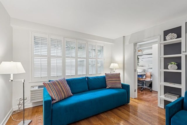 401 E 74th St Unit 2P, New York City, NY 10021 - living room featuring a desk, wood finished floors, a wall mounted AC, and baseboards