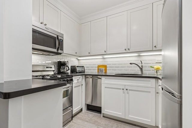 401 E 74th St Unit 2P, New York City, NY 10021 - kitchen featuring stainless steel appliances, dark countertops, backsplash, white cabinetry, and ornamental molding