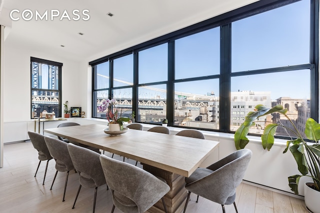 dining space with a view of city and light wood-style flooring