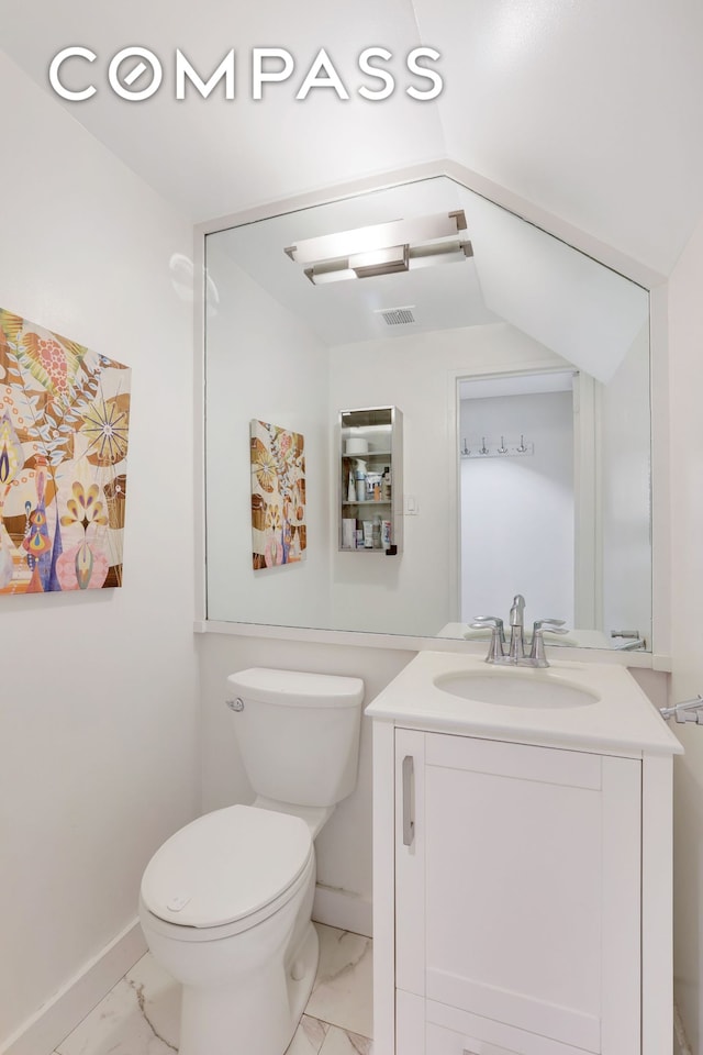 344 W 23rd St Unit 1E, New York City, NY 10011 - bathroom with marble look tiles, vanity, toilet, and baseboards