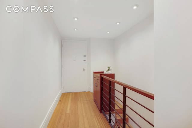 344 W 23rd St Unit 1E, New York City, NY 10011 - hallway with an upstairs landing, light wood finished floors, recessed lighting, and baseboards