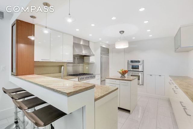 344 W 23rd St Unit 1E, New York City, NY 10011 - kitchen with wall chimney range hood, stainless steel appliances, modern cabinets, recessed lighting, and decorative backsplash
