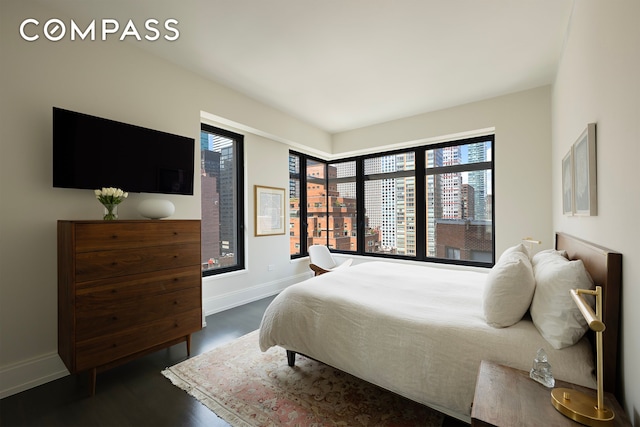 bedroom featuring baseboards and dark wood finished floors