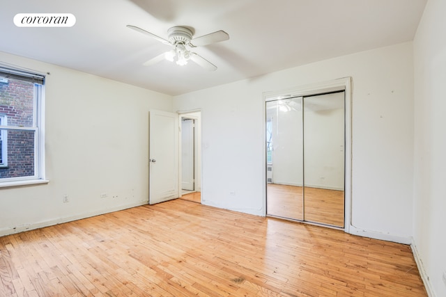 unfurnished bedroom featuring hardwood / wood-style flooring, baseboards, a ceiling fan, and a closet