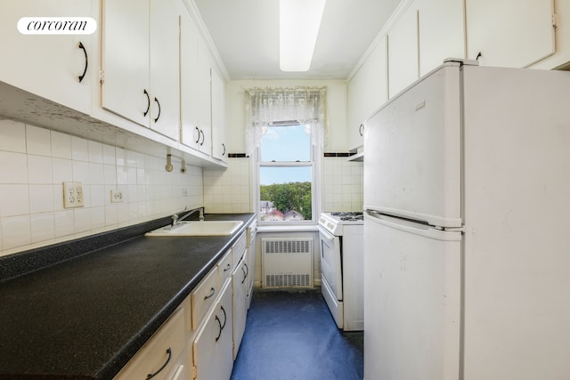 kitchen with white appliances, radiator, a sink, dark countertops, and tasteful backsplash
