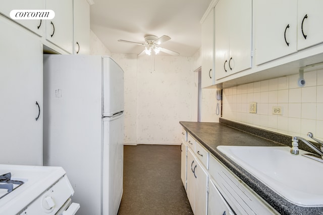 kitchen with freestanding refrigerator, a sink, ceiling fan, dark carpet, and dark countertops