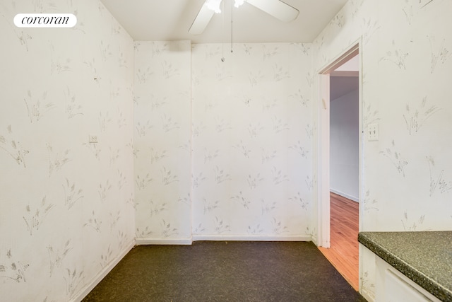 unfurnished room featuring a ceiling fan and carpet