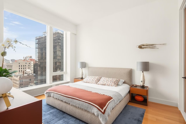 15 E 30th St Unit 21C, New York City, NY 10016 - bedroom featuring wood finished floors, baseboards, and a city view