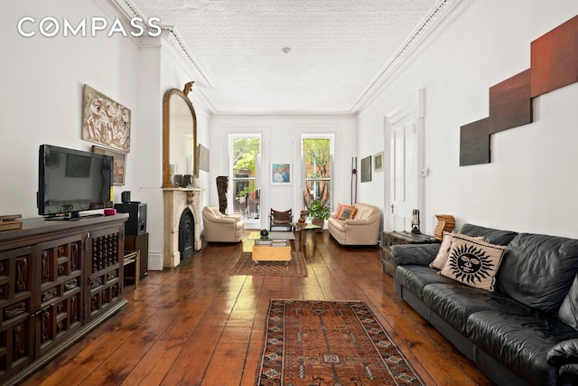 living room with ornamental molding, dark wood-style floors, and a textured ceiling