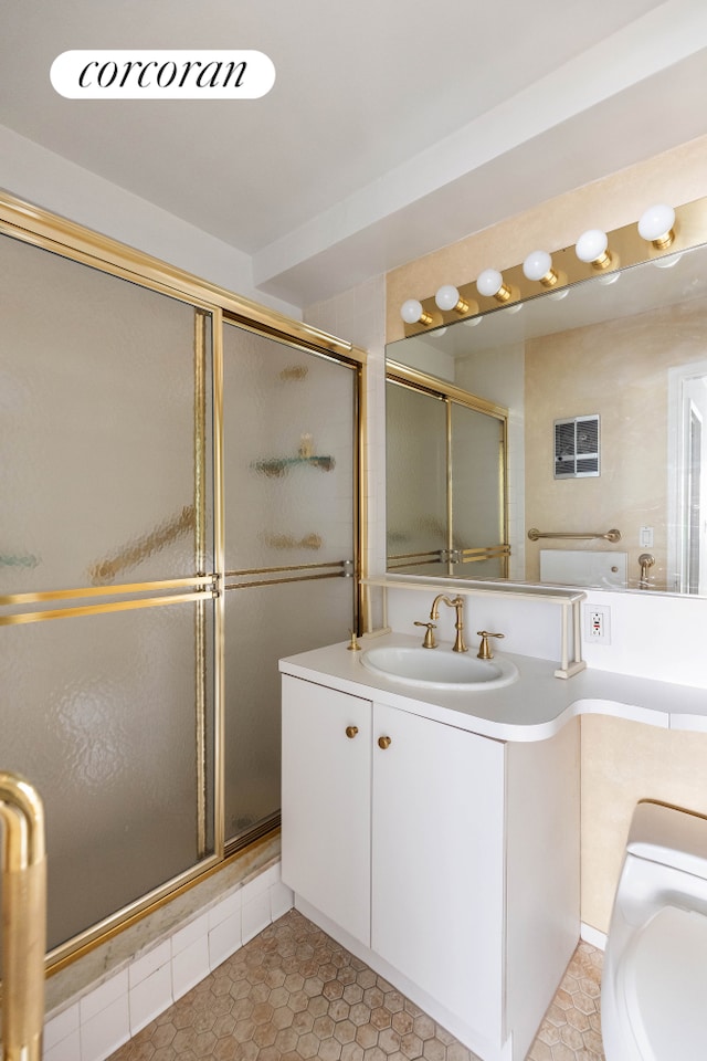 full bath featuring a stall shower, vanity, tile patterned floors, and toilet