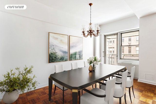 dining room featuring a chandelier and baseboards