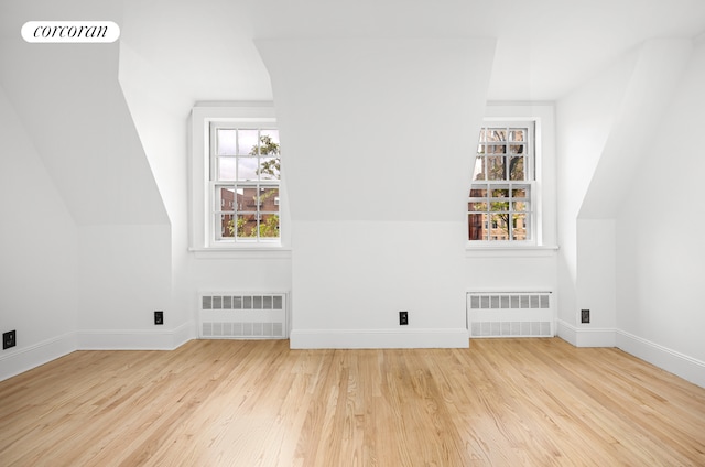 bonus room featuring radiator, wood finished floors, and baseboards