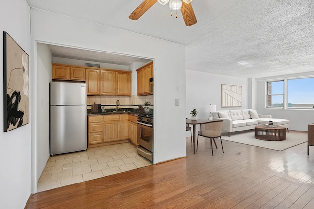1655 Flatbush Ave Unit C2105, New York City, NY 11210 - kitchen featuring appliances with stainless steel finishes, open floor plan, dark countertops, a sink, and ceiling fan