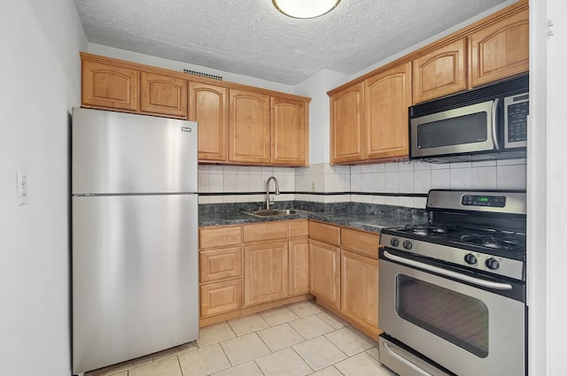 1655 Flatbush Ave Unit C2105, New York City, NY 11210 - kitchen with appliances with stainless steel finishes, a sink, light tile patterned flooring, a textured ceiling, and decorative backsplash