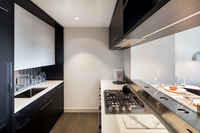 252 S St Unit 63G, New York City, NY 10002 - kitchen featuring dark cabinetry, a sink, dark wood finished floors, light countertops, and backsplash