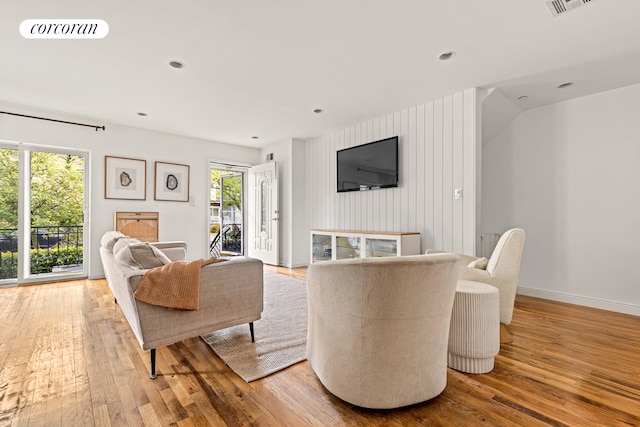 195 Bch 125th St Unit 1C, New York City, NY 11694 - living area with plenty of natural light, hardwood / wood-style floors, and baseboards