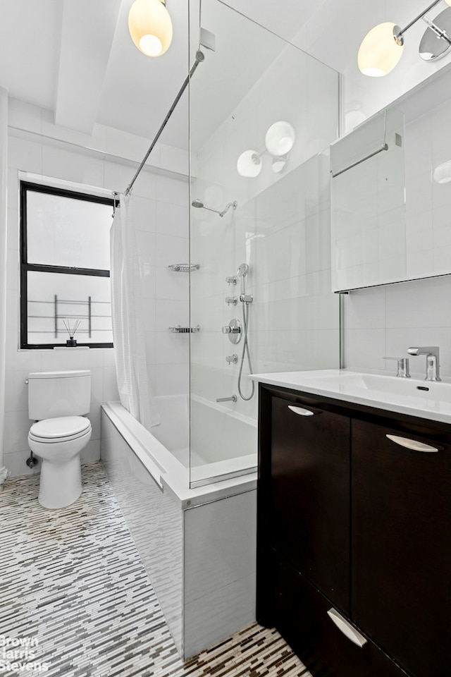 bathroom with tile walls, toilet, shower / bath combo, and vanity