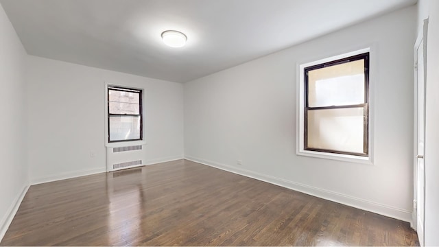 221 E 18th St Unit 1E, New York City, NY 11226 - spare room with dark wood-style floors and baseboards