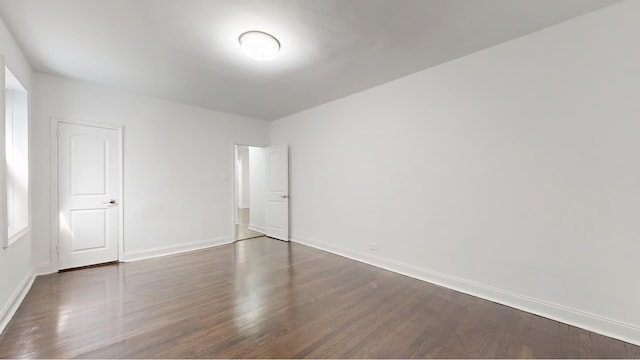 221 E 18th St Unit 1E, New York City, NY 11226 - unfurnished bedroom with baseboards and dark wood finished floors
