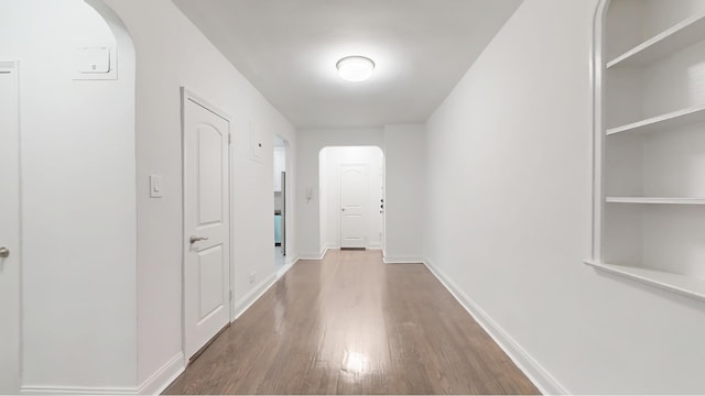 221 E 18th St Unit 1E, New York City, NY 11226 - hallway featuring wood finished floors, arched walkways, and baseboards