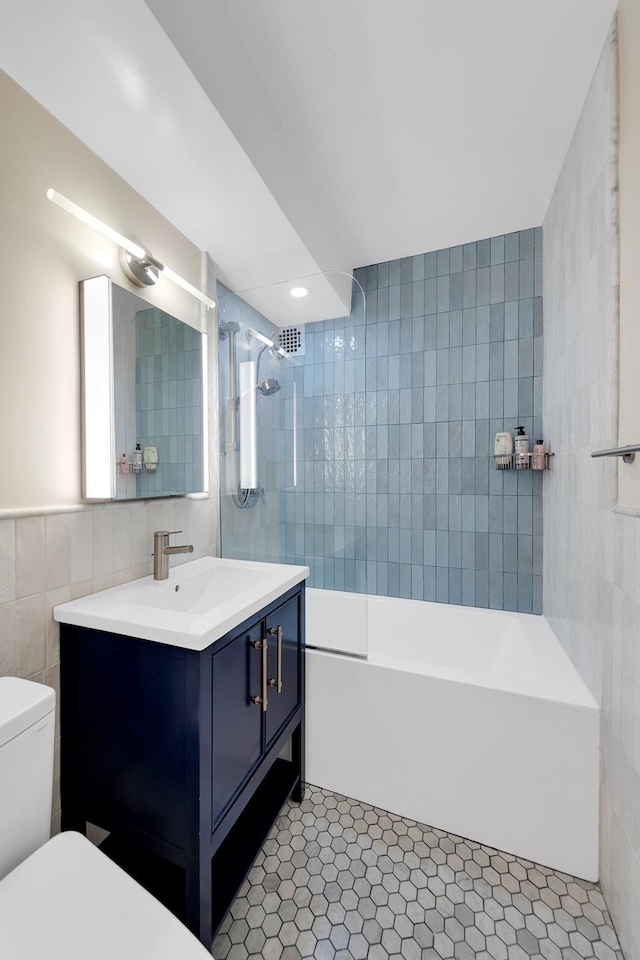 446 E 86th St Unit 7C, New York City, NY 10028 - full bathroom featuring tile walls, vanity, tub / shower combination, tile patterned flooring, and recessed lighting