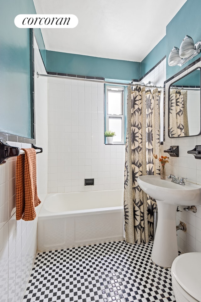 bathroom with tile walls, tile patterned floors, toilet, and shower / bath combination with curtain