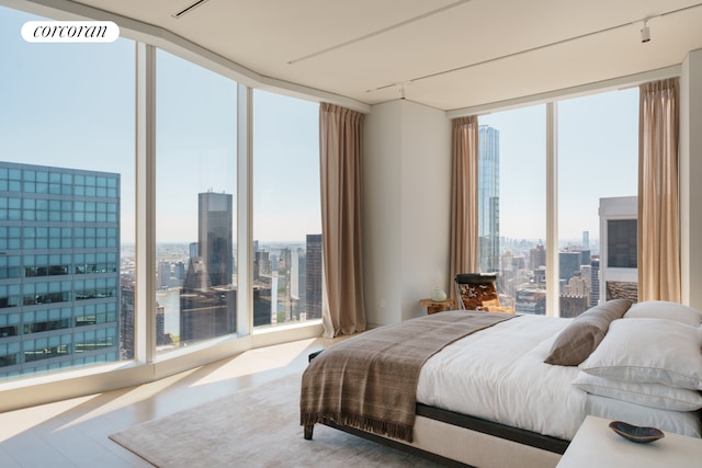 bedroom featuring a wall of windows and a city view