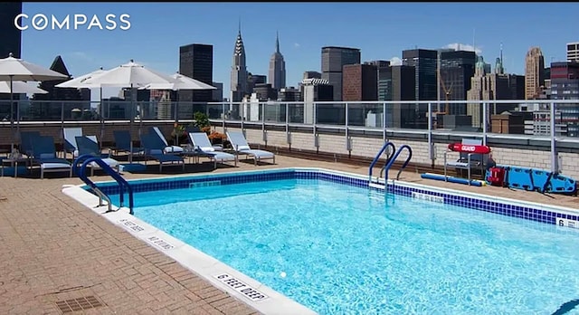 community pool featuring fence and a skyline view